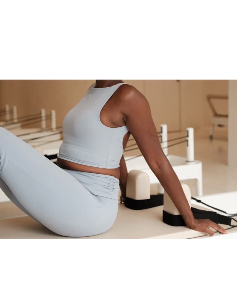 Pilates client seated on a reformer in the Alva studio